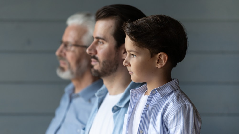 a profile of three men - a young boy, an older men, and a grandfather
